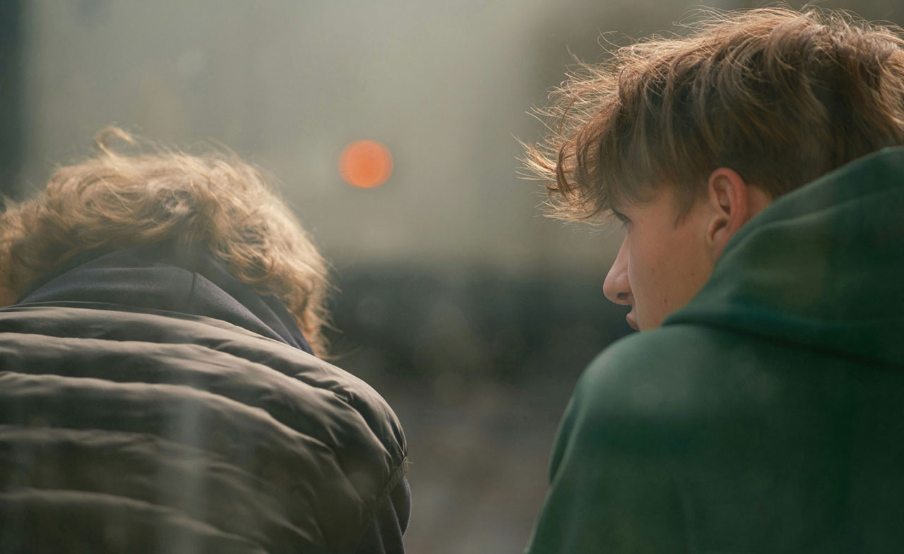 A photo of two teenage boys communicating their feelings to each other.