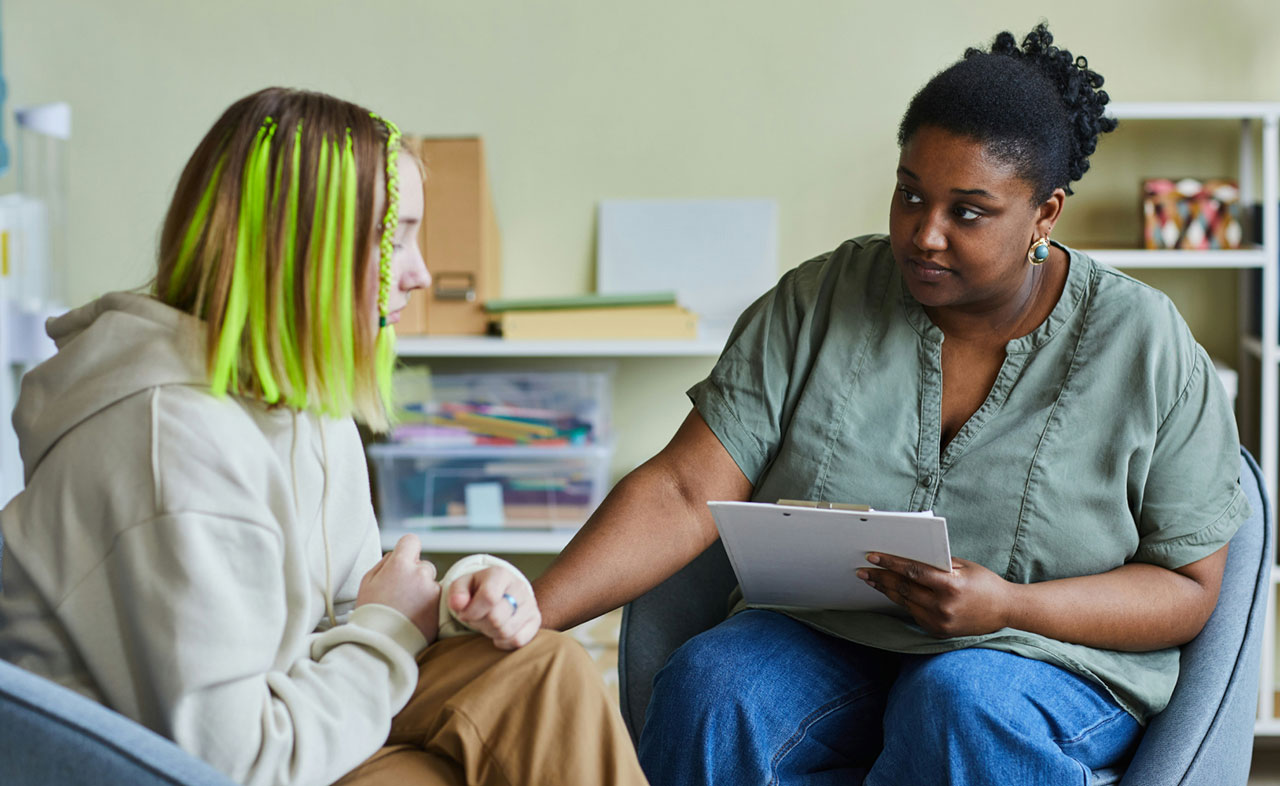 Photo of a therapist listening to a teen