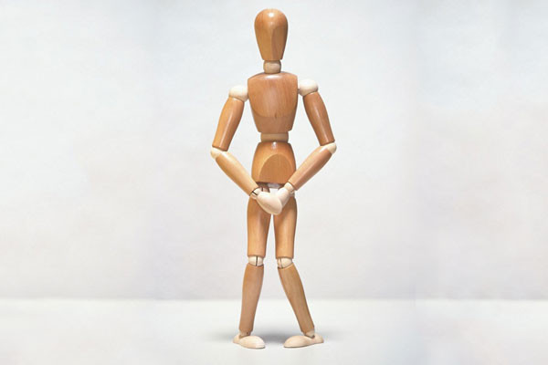 photo of a wooden model of a human figure with its hands over its crotch