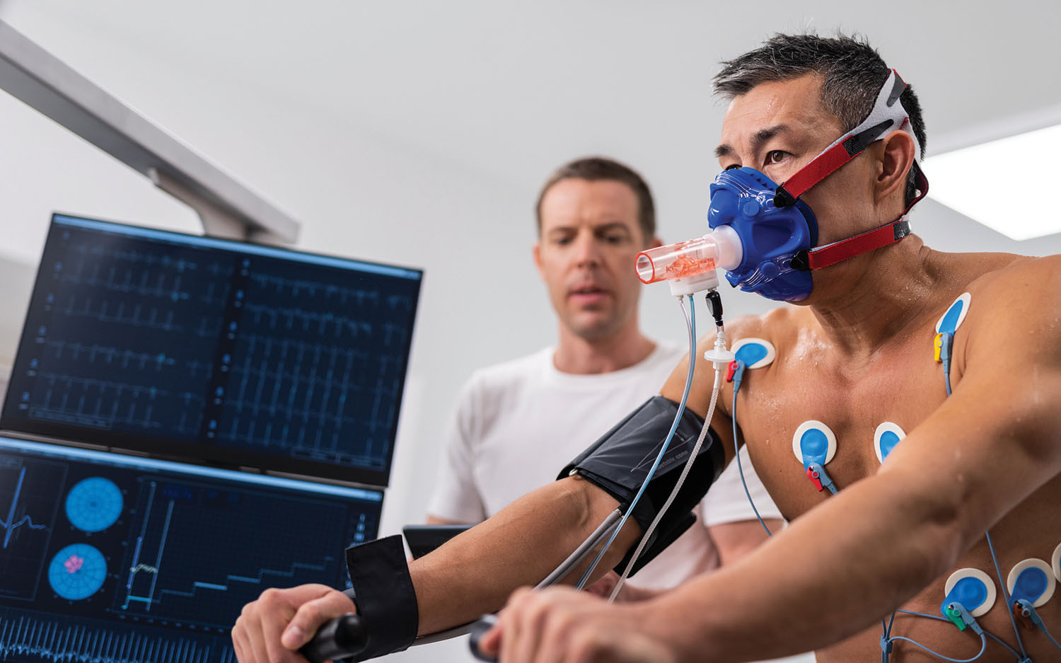 photo of a man undergoing a cardiopulmonary exercise testing stress test with assistance from a medical professional