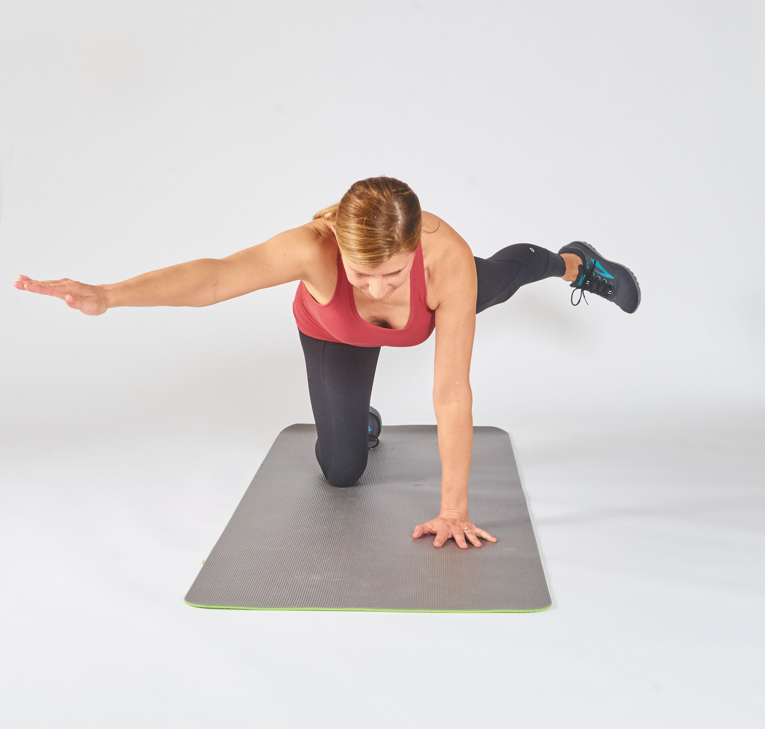 photo of a person performing the opposite arm and leg raise exercise, showing how to make it more difficult