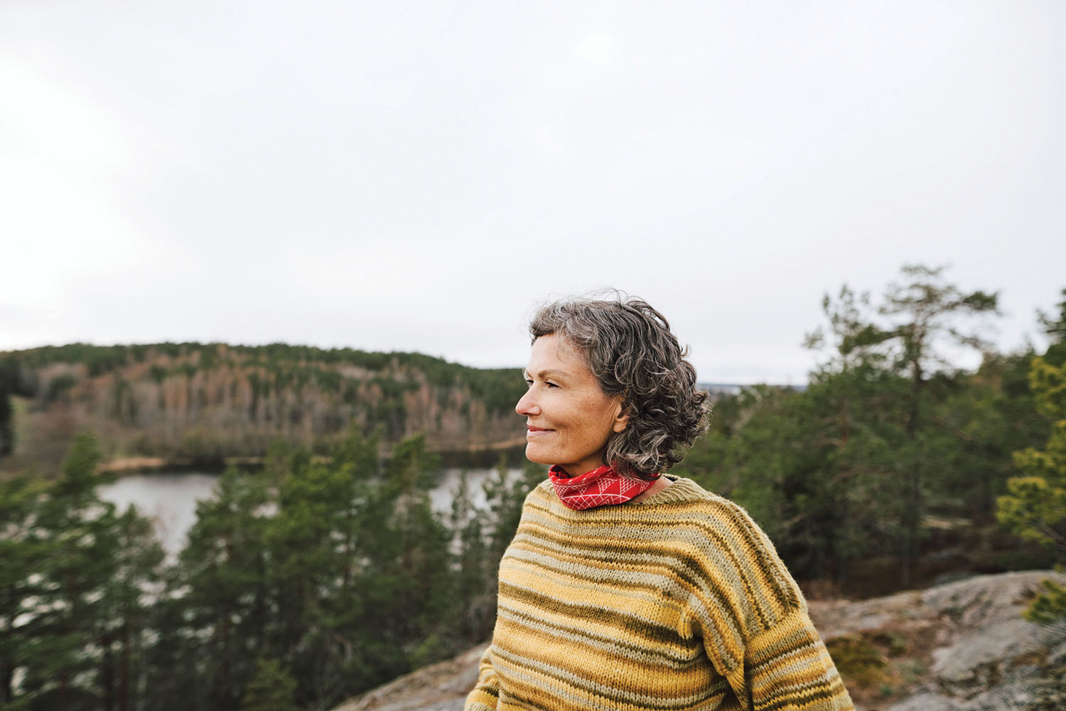 photo of a woman enjoying a walk outdoors, smiling as she makes extra effort to notice her surroundings