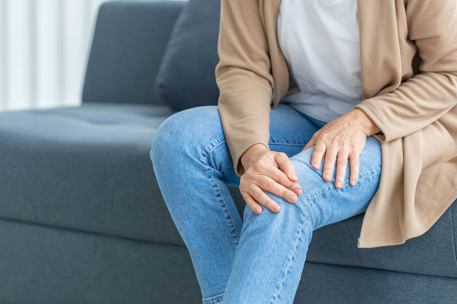 cropped photo of a person holding their sore knee