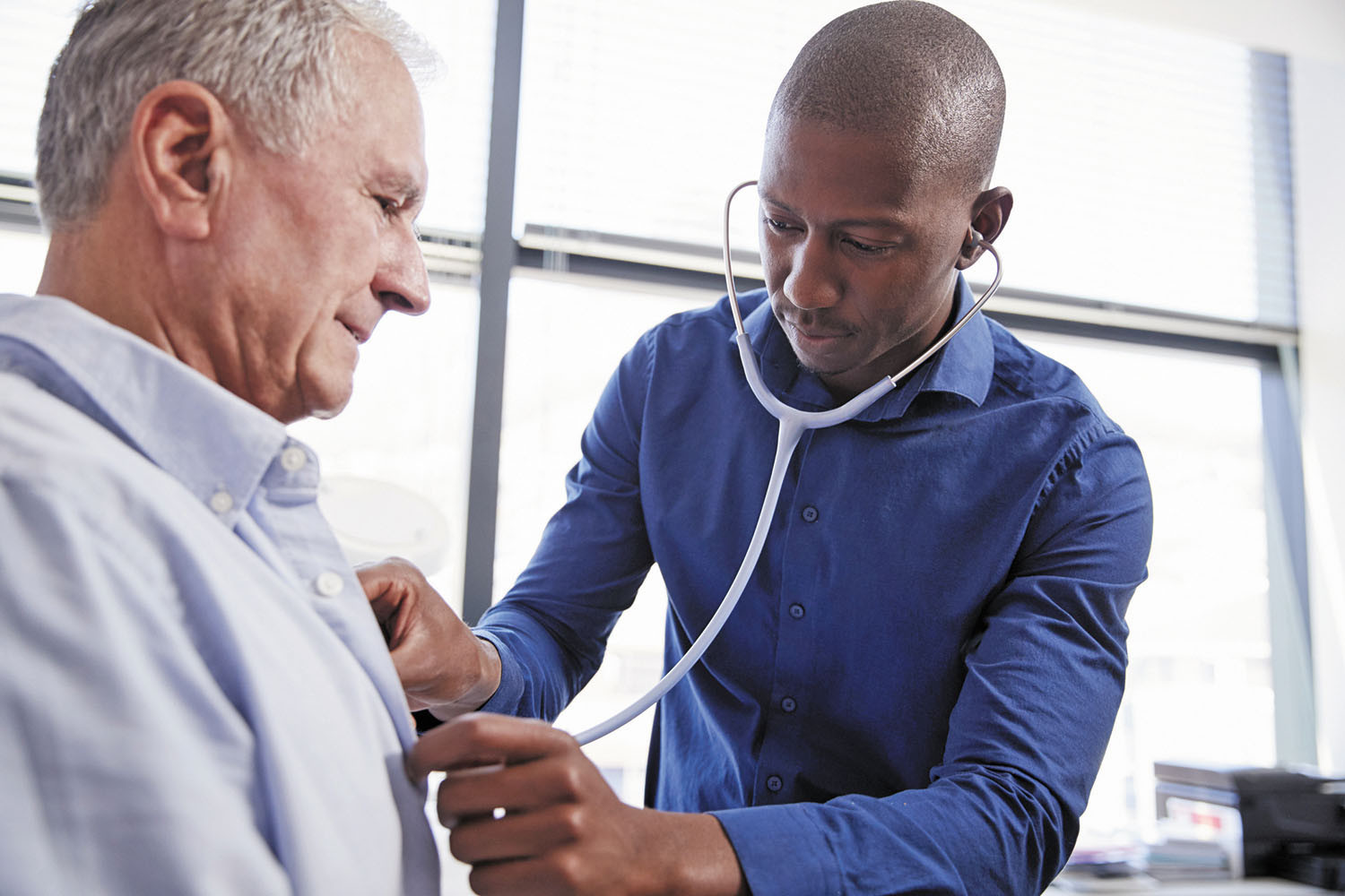 photo of a doctor listening to a patient's heart using a stethoscope