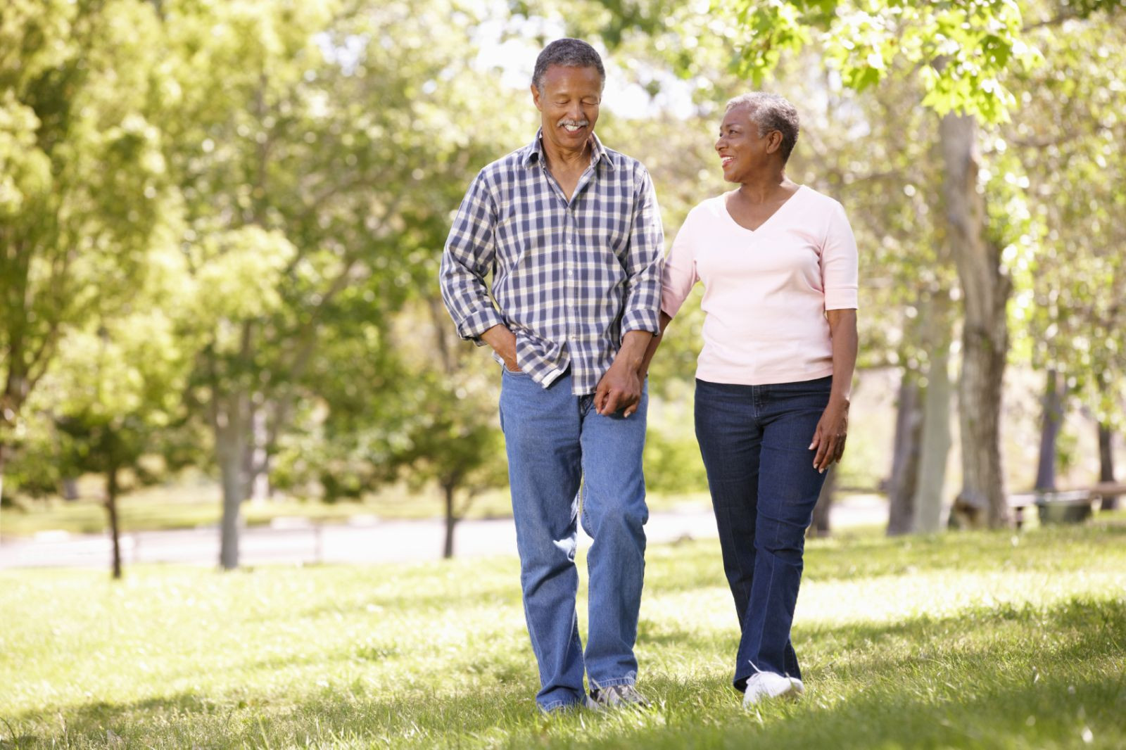 A man and a woman walking through a park