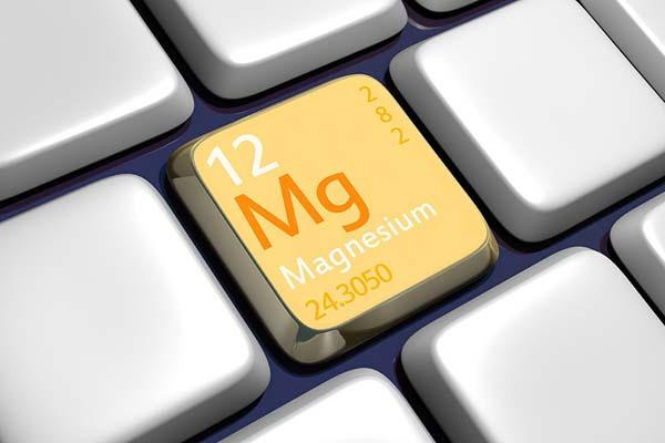 Close-up of a computer keyboard, the keys are silver except one that has a yellow background and is labeled with the number 12 and Mg, the periodic table symbol for the element magnesium.