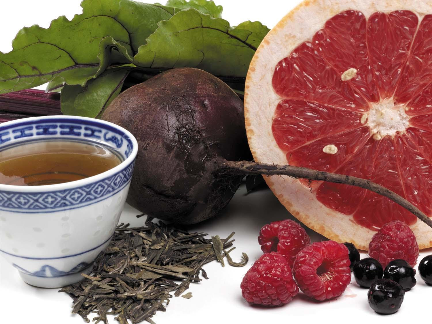 An assortment of flaovnoid-rich foods: tea, beets, grapefruit, and berries.