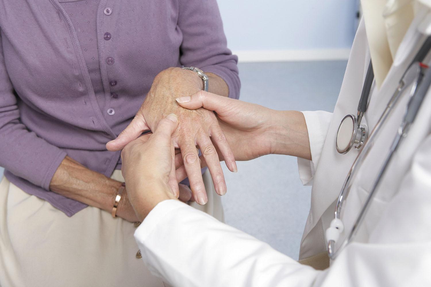 Doctor examines a patient's hands.