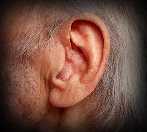 A person's ear ringing from tinnitus.