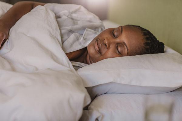 Woman rests peacefully in her bed.