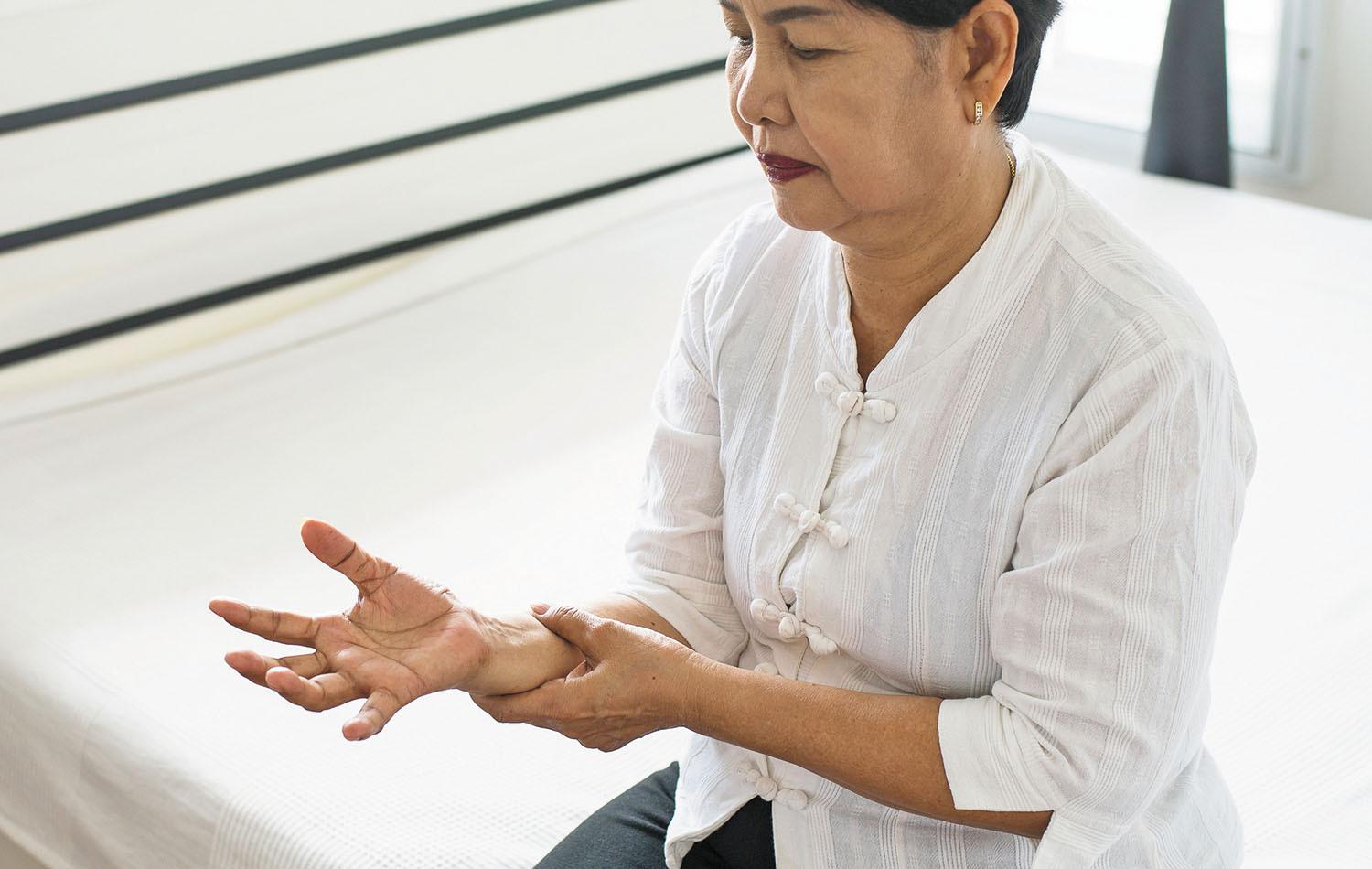 A woman sitting on a bed with her hands open