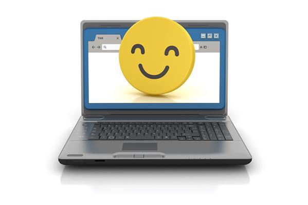 An open laptop shows an illustration of a web browser and a large smiling yellow emoji filling the screen.