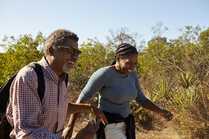 A man and a woman walking through a field