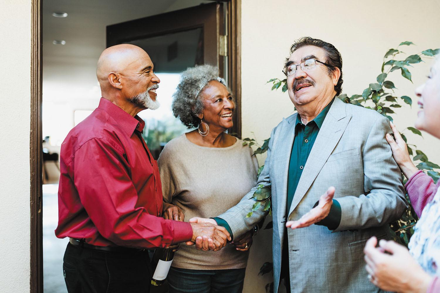 A group of people with two men shaking hands