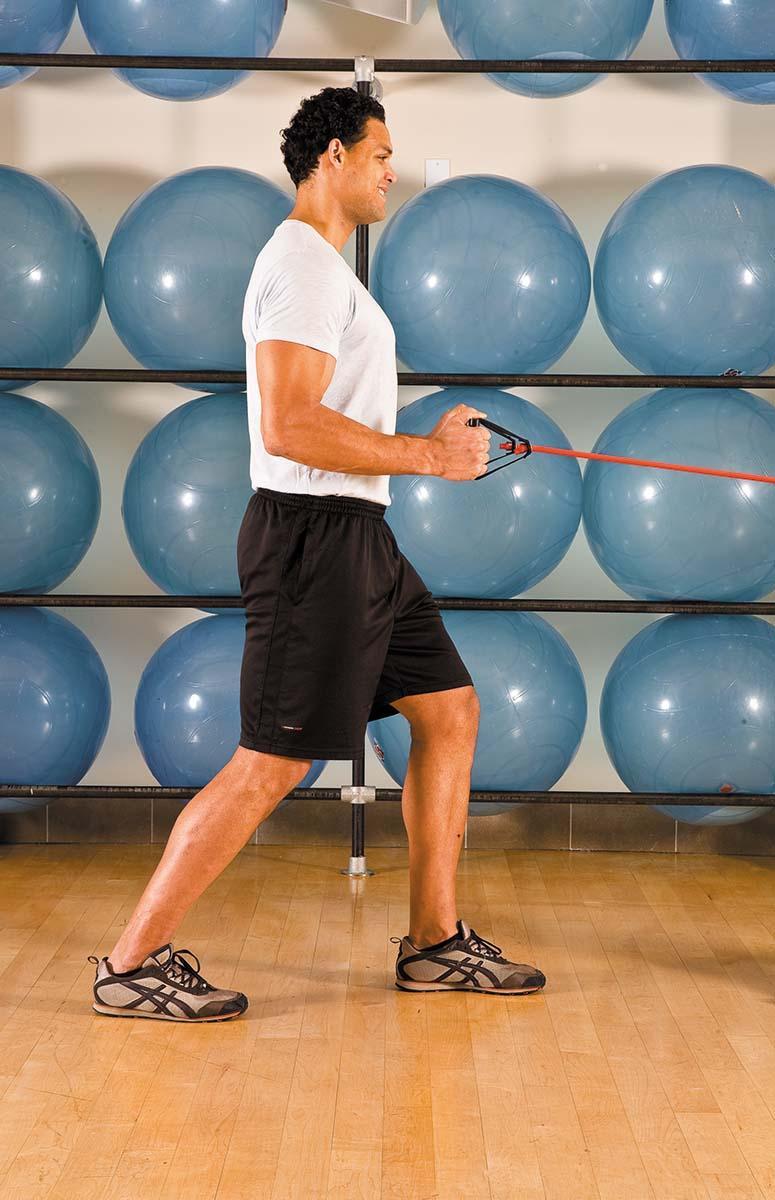 A man shows the movement for the standing row exercise as described in the article.
