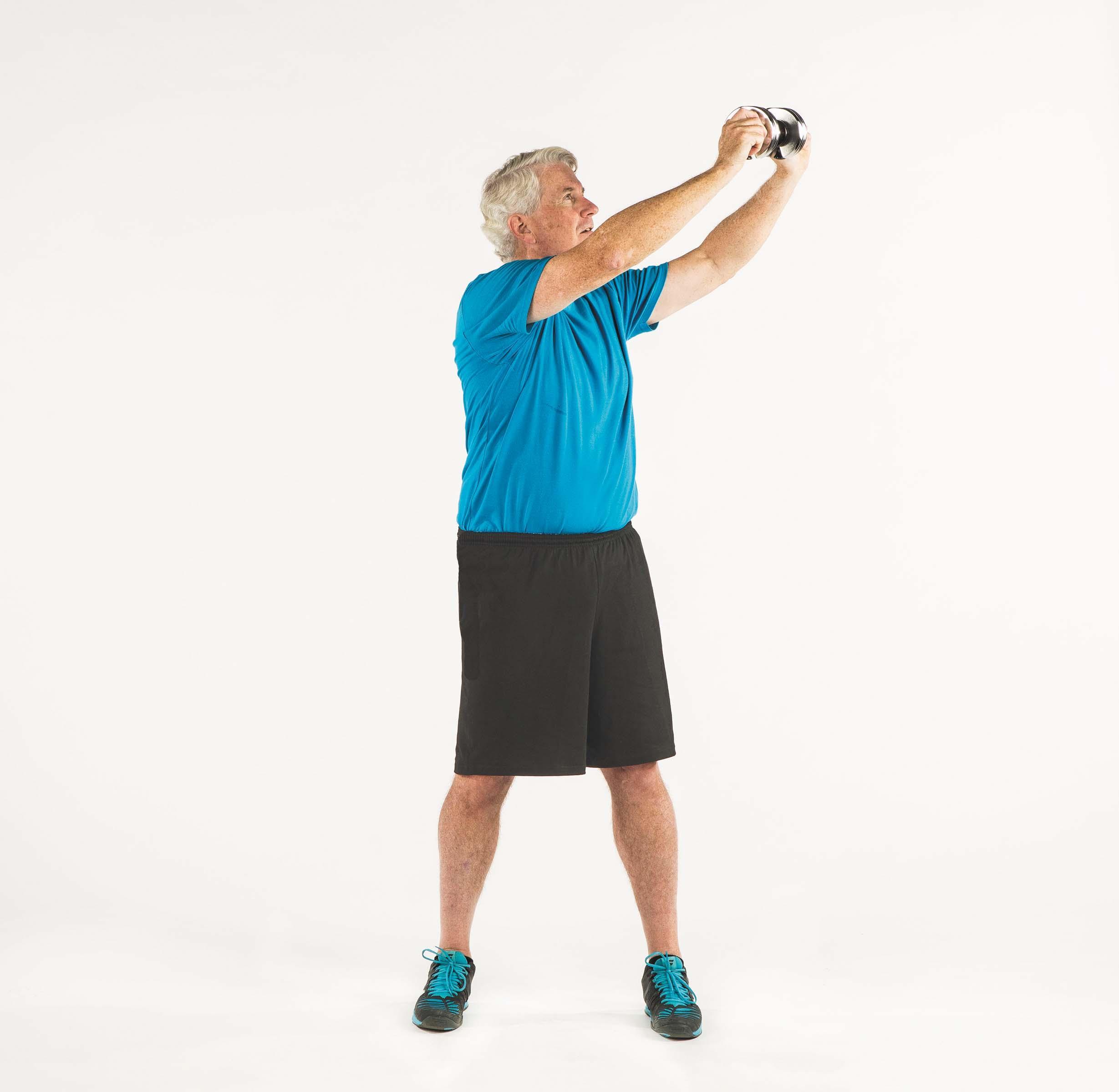 A man shows the movement for the wood chop exercise as described in the article.