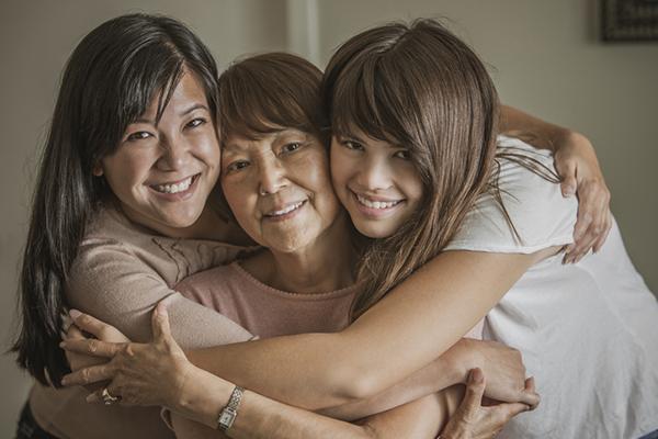 Three generations of women hugging: from left, mother, grandmother, and daughter.