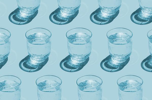 Glasses of water arranged in rows, with shadows from sunlight, on a light blue background.