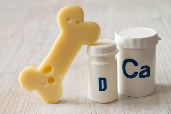 How do vitamin D and calcium work together to keep bones strong?