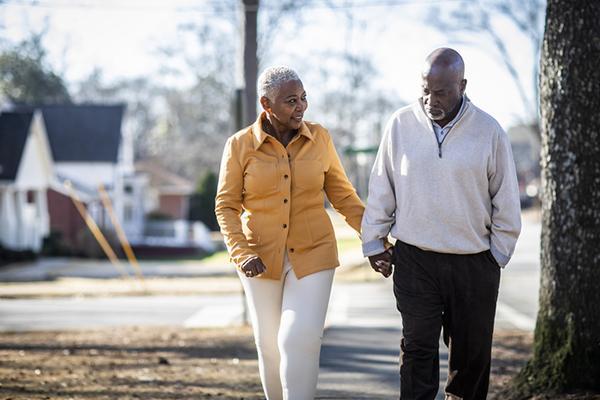 A senior couple walking on a suburban street.