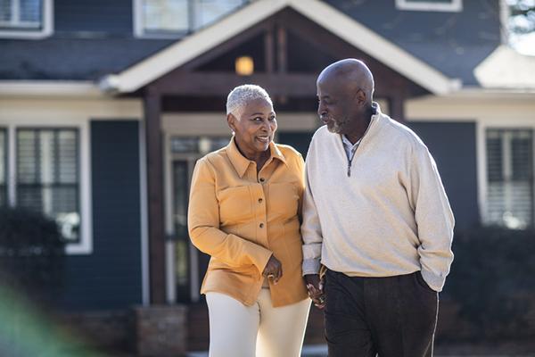 A senior couple taking a walk outside on a sunny day.