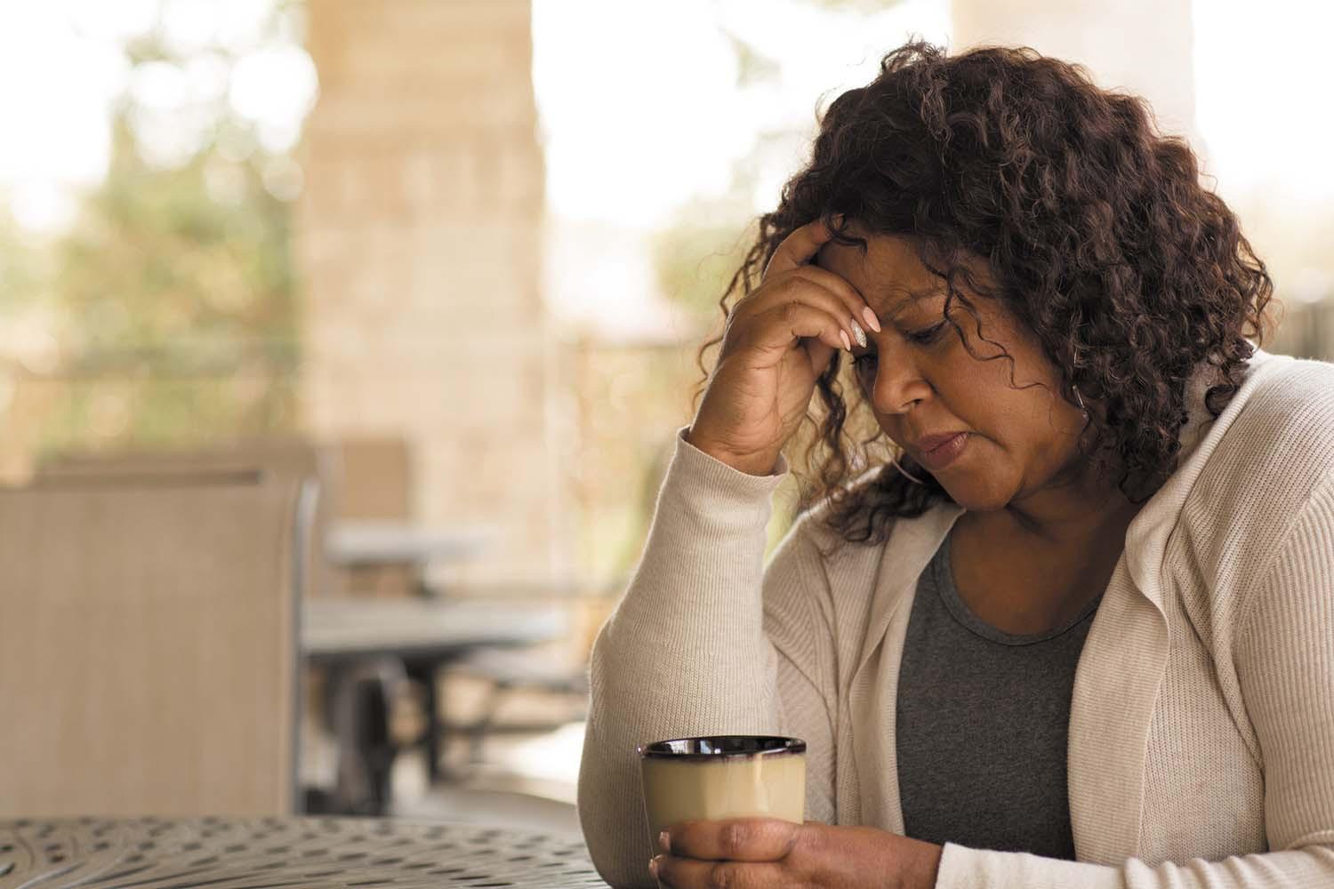 Woman worries with her hand on her head
