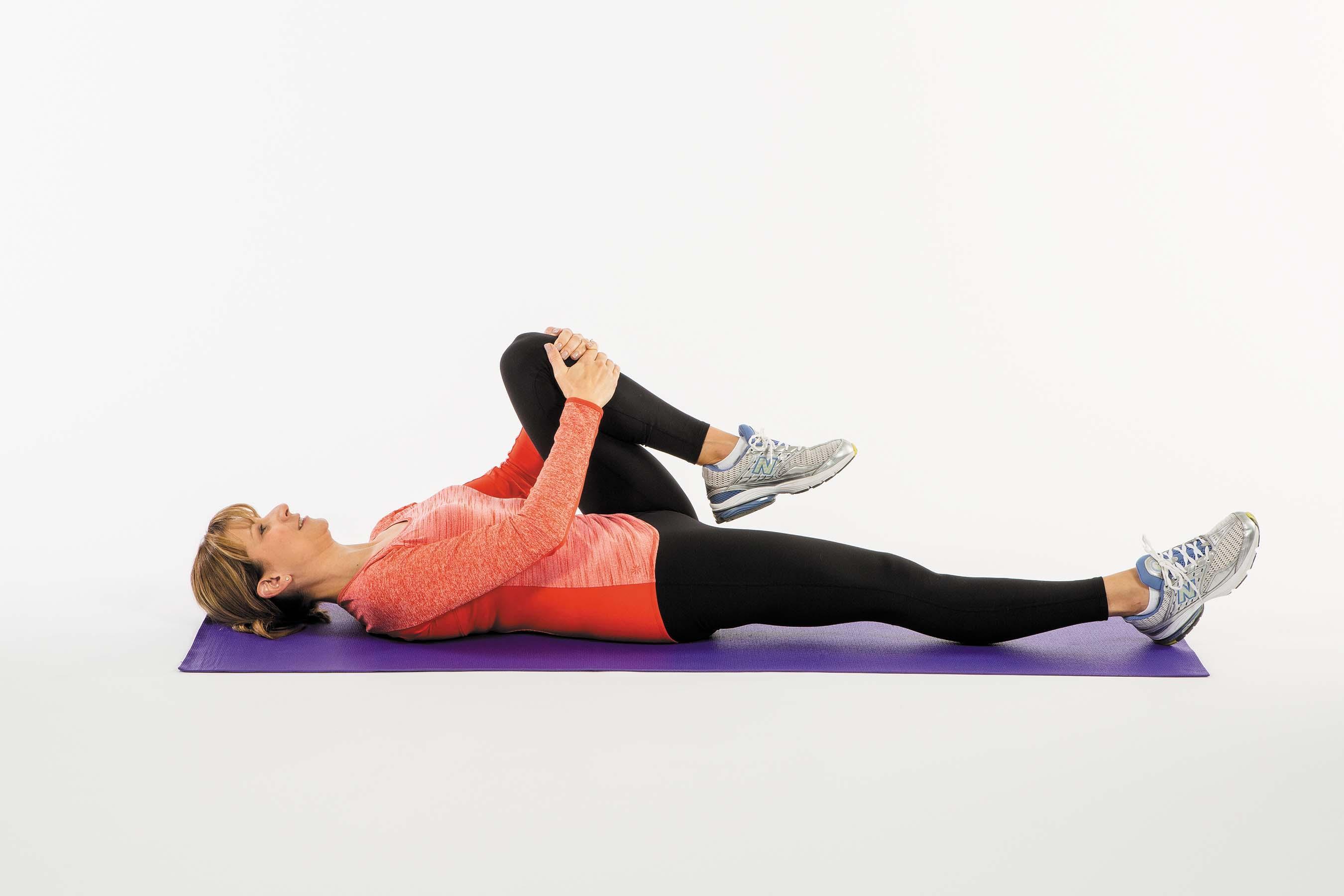 A woman performs the knees to chest exercise as described in the article.
