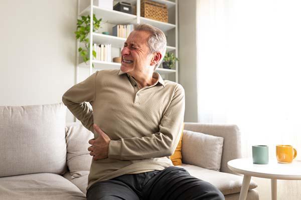 Can a pinched spinal nerve cause intense belly and back pain?