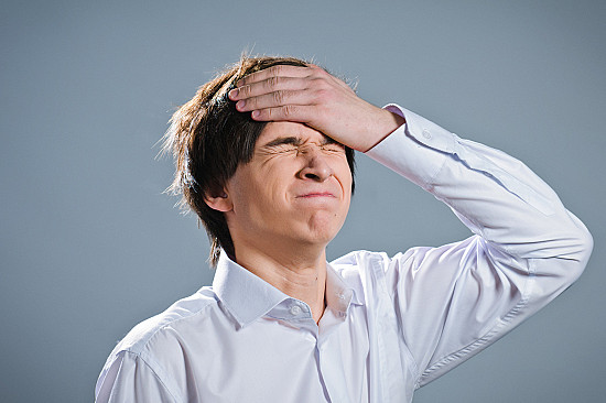 Young man suffering from flank pain on grey background Stock Photo