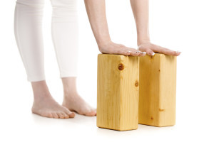 doing variation of Ardha Uttanasana pose, studio three-quarters view on white background, isolated