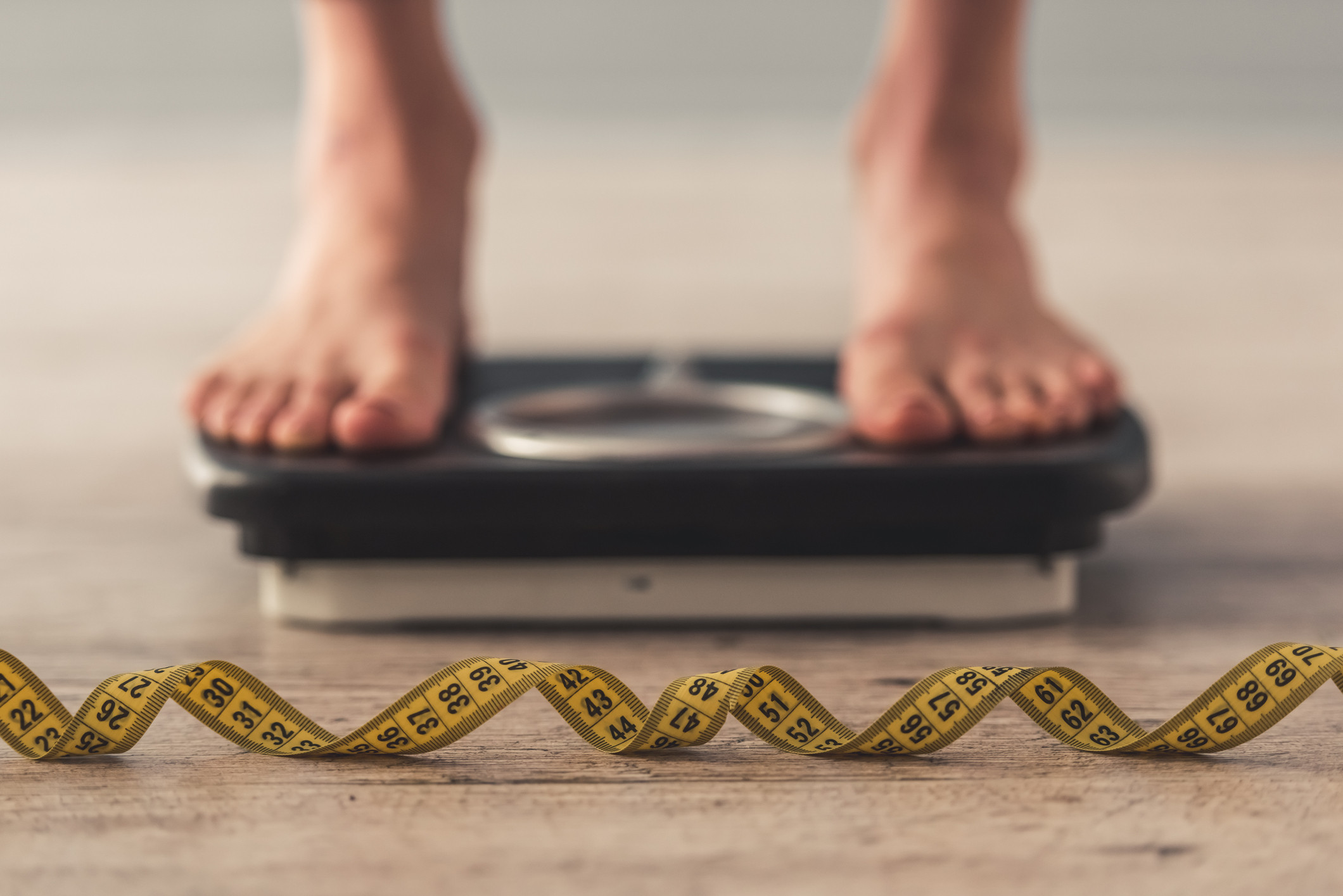 Man Standing On Weighing Scales #1 by Science Photo Library